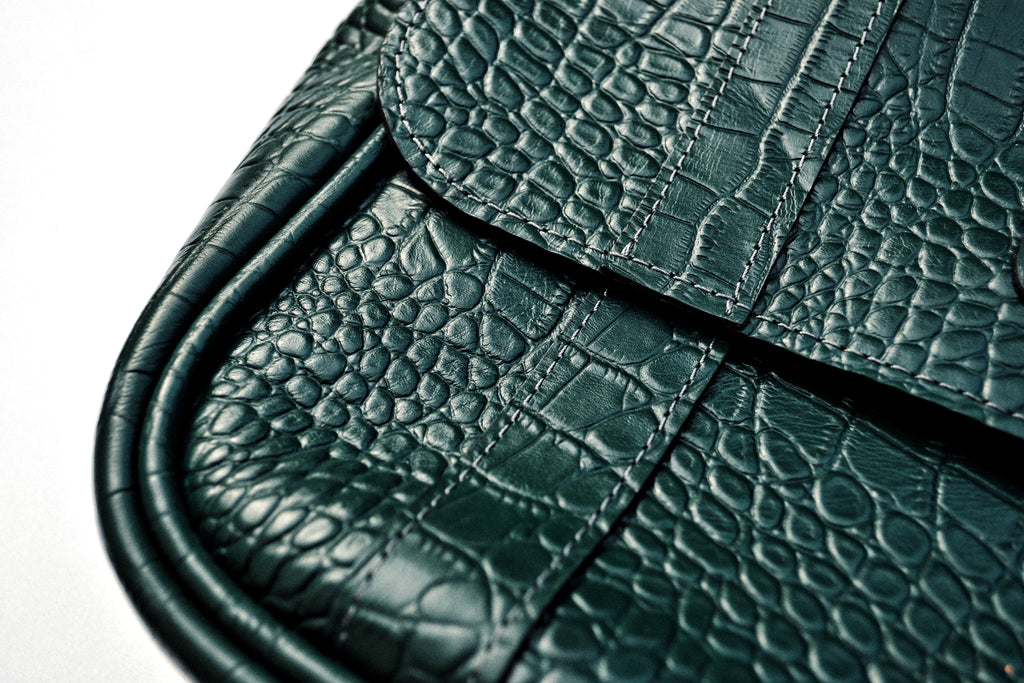 Close-up of a green textured messenger bag