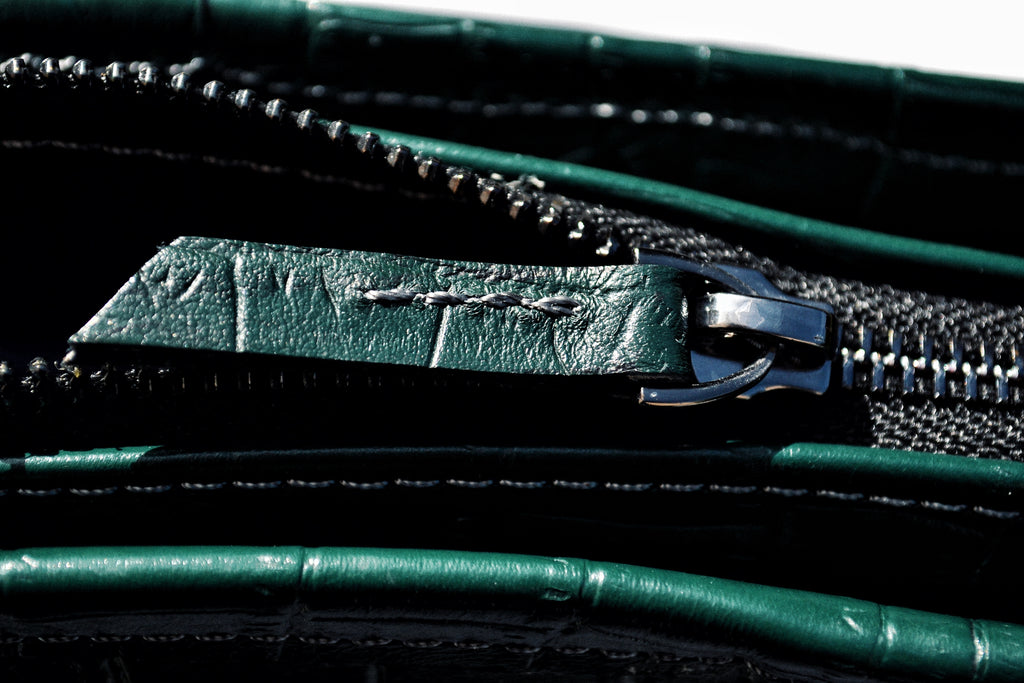 Close-up of a green leather wallet with a zipper